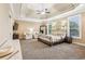 Spacious main bedroom featuring a decorative tray ceiling, seating area, and carpet at 3480 Indian Shoals Rd, Dacula, GA 30019