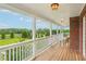 Inviting covered porch with white railings overlooks a lush, green landscape at 3480 Indian Shoals Rd, Dacula, GA 30019