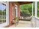Inviting farmhouse porch with swing, brick accents, and charming decor at 3480 Indian Shoals Rd, Dacula, GA 30019