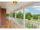 Inviting covered porch with white railings overlooks a lush, green landscape at 3480 Indian Shoals Rd, Dacula, GA 30019