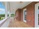 Spacious covered porch with brick accents offers outdoor relaxation and views at 3480 Indian Shoals Rd, Dacula, GA 30019