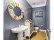 Charming powder room features a pedestal sink, unique mirror and decorative accents at 3480 Indian Shoals Rd, Dacula, GA 30019