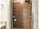 Close up of a tiled shower with a rainfall showerhead, handheld wand, and storage caddy at 3480 Indian Shoals Rd, Dacula, GA 30019