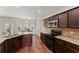 Updated kitchen with granite countertops, dark wood cabinets, and modern appliances at 403 Sonja Ln, Loganville, GA 30052