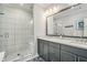 Bright bathroom with dual sinks, granite countertops and glass shower door at 710 Elmwood Way, Roswell, GA 30075
