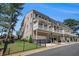 View of the side exterior of a multi-story townhouse with private balconies and a well manicured lawn at 710 Elmwood Way, Roswell, GA 30075