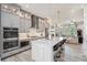 Open-concept kitchen with stainless appliances, large island, and stylish gray cabinetry at 710 Elmwood Way, Roswell, GA 30075