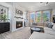 Cozy living room featuring a modern fireplace, plush seating, and bright windows with natural light at 710 Elmwood Way, Roswell, GA 30075