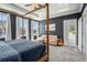 A well-lit main bedroom with a seating area and a beautiful four poster bed at 710 Elmwood Way, Roswell, GA 30075