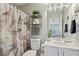 A well-lit bathroom featuring a vanity, toilet, and shower with stylish curtain at 1017 Preserve Park Dr, Loganville, GA 30052