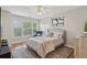 Cozy bedroom with a tufted headboard, ceiling fan, and large window at 1017 Preserve Park Dr, Loganville, GA 30052