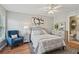 Comfortable bedroom with an upholstered headboard, blue chair, and ensuite bathroom at 1017 Preserve Park Dr, Loganville, GA 30052