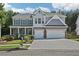 Charming two-story home features a well-manicured lawn, a two-car garage, and an inviting covered front porch at 1017 Preserve Park Dr, Loganville, GA 30052