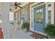Inviting front porch with rocking chairs, ceiling fans, and a decorative blue front door at 1017 Preserve Park Dr, Loganville, GA 30052