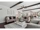 Open-concept living room featuring exposed beams and hardwood floors, steps to the kitchen at 1017 Preserve Park Dr, Loganville, GA 30052