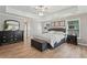 Comfortable bedroom with a large bed, dresser, and bench, featuring wood floors and a ceiling fan at 1017 Preserve Park Dr, Loganville, GA 30052