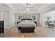 Bright and airy bedroom with wood flooring, a ceiling fan, and a glimpse into the sitting room at 1017 Preserve Park Dr, Loganville, GA 30052
