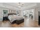 Bright and airy bedroom with wood flooring, ceiling fan, fireplace, and view to the sitting room at 1017 Preserve Park Dr, Loganville, GA 30052