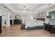Bright bedroom featuring a ceiling fan, wood floors, and a comfortable bed near a doorway at 1017 Preserve Park Dr, Loganville, GA 30052