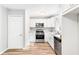 Well-lit kitchen with stainless steel appliances, white cabinetry, stylish countertops, and wood-look flooring at 127 Danielle Ct, Villa Rica, GA 30180
