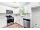 Updated kitchen with stainless steel appliances, granite countertops, white cabinets, and vinyl plank flooring at 127 Danielle Ct, Villa Rica, GA 30180