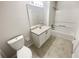 Clean bathroom featuring a vanity, toilet, and shower-tub combination with white tiling at 1503 Colt Ridge Se Ln, Mableton, GA 30126