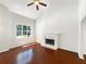 Bright living room with a fireplace, hardwood floors, vaulted ceilings, and a large sunny window at 1503 Colt Ridge Se Ln, Mableton, GA 30126