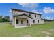 View of the rear exterior, featuring a covered patio and well-manicured lawn at 157 Haverling Pass, Hampton, GA 30228