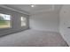 Bedroom featuring neutral walls, plush carpeting, and dual windows for natural light at 157 Haverling Pass, Hampton, GA 30228