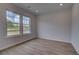 Neutral bedroom features wood flooring, recessed lighting, and a large window with view to the outdoors at 157 Haverling Pass, Hampton, GA 30228