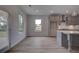 Bright kitchen design with gray cabinets, an island with pendant lighting, and wood flooring at 157 Haverling Pass, Hampton, GA 30228