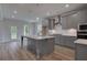 Bright kitchen features gray cabinets, stainless steel appliances, and an island with pendant lighting at 157 Haverling Pass, Hampton, GA 30228