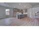Open concept kitchen with gray cabinets, stainless steel appliances and wood flooring at 157 Haverling Pass, Hampton, GA 30228