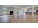 Bright open-concept living room and kitchen area with wood flooring and a fireplace at 157 Haverling Pass, Hampton, GA 30228