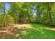 Spacious back yard featuring mature trees and a storage shed at 2617 Laurel Woods Se Ln, Conyers, GA 30094