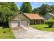 Charming one-story home featuring an attached two-car garage, mature trees, and a well-maintained lawn at 2617 Laurel Woods Se Ln, Conyers, GA 30094