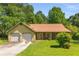 Charming one-story home featuring an attached two-car garage, mature trees, and a well-maintained lawn at 2617 Laurel Woods Se Ln, Conyers, GA 30094