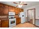Charming kitchen equipped with wood cabinets, white appliances, and a ceiling fan at 2617 Laurel Woods Se Ln, Conyers, GA 30094