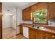 Classic kitchen with wood cabinetry, a double sink, and a view to the dining area at 2617 Laurel Woods Se Ln, Conyers, GA 30094