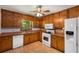 Traditional kitchen featuring wood cabinets, white appliances, and a view of the outdoors at 2617 Laurel Woods Se Ln, Conyers, GA 30094