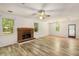 Spacious living room featuring a brick fireplace, wood-look floors, and a charming chandelier at 2617 Laurel Woods Se Ln, Conyers, GA 30094