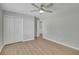 Bright bedroom with ceiling fan, light-colored floor, walls, closet, and view into the hall at 4516 Creekwood Circle Nw, Kennesaw, GA 30152