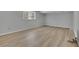 Bright bedroom featuring sleek hardwood floors, a large window, and neutral walls at 4516 Creekwood Circle Nw, Kennesaw, GA 30152