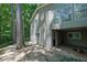 Home exterior with stone patio, large windows and walk-out door in a beautiful wooded setting at 4516 Creekwood Circle Nw, Kennesaw, GA 30152