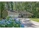 Charming home with attached garage, circular driveway, and landscaped front yard with blue hydrangeas at 4516 Creekwood Circle Nw, Kennesaw, GA 30152
