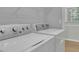 Bright laundry room featuring a white washer and dryer and a window with natural light at 4516 Creekwood Circle Nw, Kennesaw, GA 30152