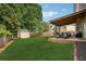 Spacious backyard with lush green grass, a shed, and an inviting covered patio area at 75 Hunters Ct, Dallas, GA 30157