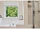 Bright bathroom features a soaking tub with a view from a window and separate shower at 75 Hunters Ct, Dallas, GA 30157