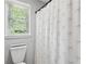 Bathroom with a decorative shower curtain, toilet, and natural lighting at 75 Hunters Ct, Dallas, GA 30157