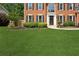 Two-story brick home with a lush green lawn, featuring classic architecture and tidy landscaping at 75 Hunters Ct, Dallas, GA 30157